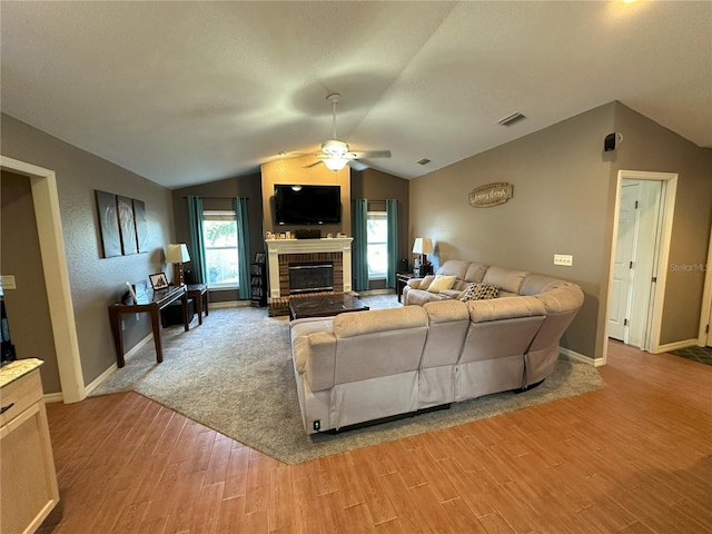 1140 Odoniel Loop S, Lakeland, FL 33809 - living room featuring light wood-style floors, vaulted ceiling, ceiling fan, and a brick fireplace