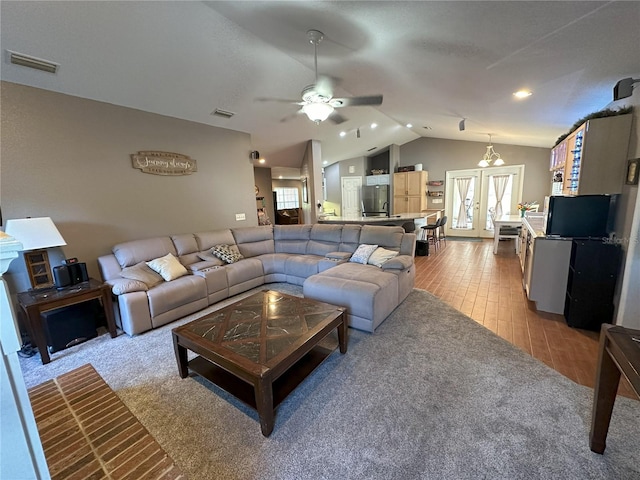 1140 Odoniel Loop S, Lakeland, FL 33809 - living room with vaulted ceiling, french doors, ceiling fan, light wood-type flooring, and light colored carpet
