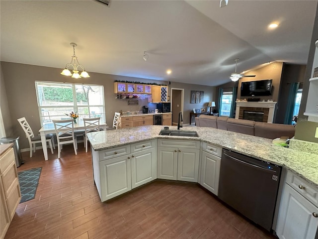 1140 Odoniel Loop S, Lakeland, FL 33809 - kitchen featuring stainless steel dishwasher, ceiling fan, dark wood-style flooring, light stone counters, and lofted ceiling
