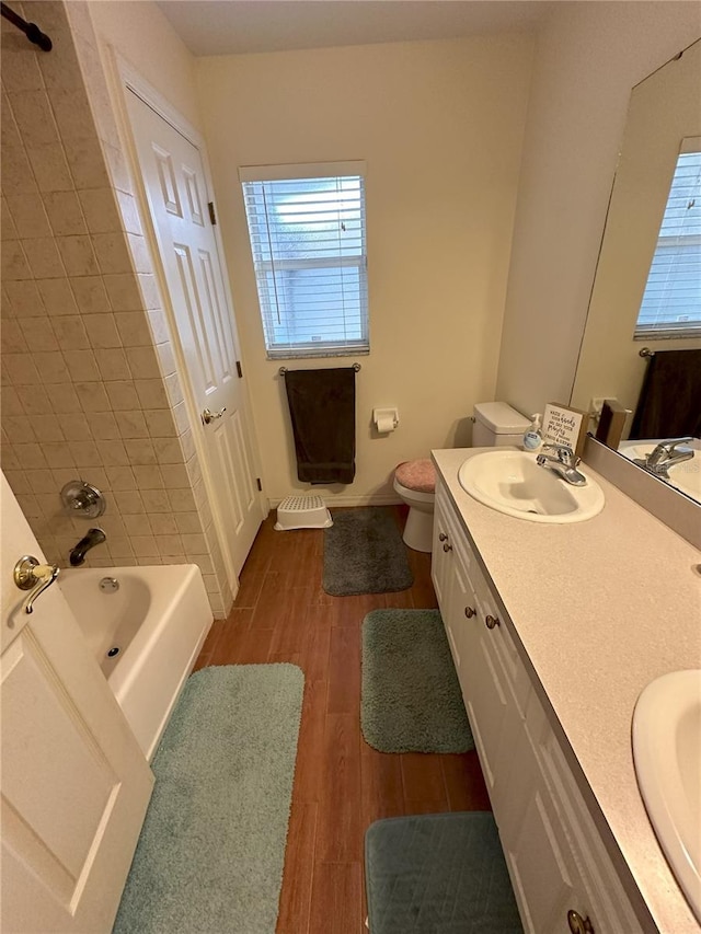 1140 Odoniel Loop S, Lakeland, FL 33809 - bathroom featuring double vanity, wood finished floors, and shower / tub combination