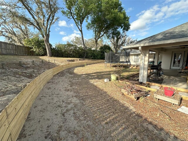 1140 Odoniel Loop S, Lakeland, FL 33809 - view of yard featuring a trampoline and a patio area