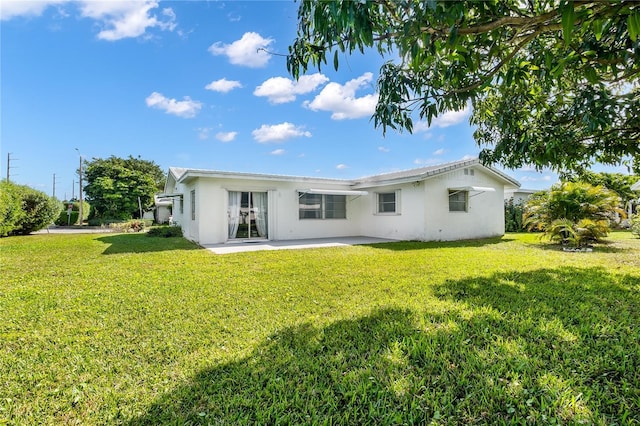 1501 SW 18th Dr, Boynton Beach, FL 33426 - rear view of property featuring stucco siding, a patio area, and a lawn