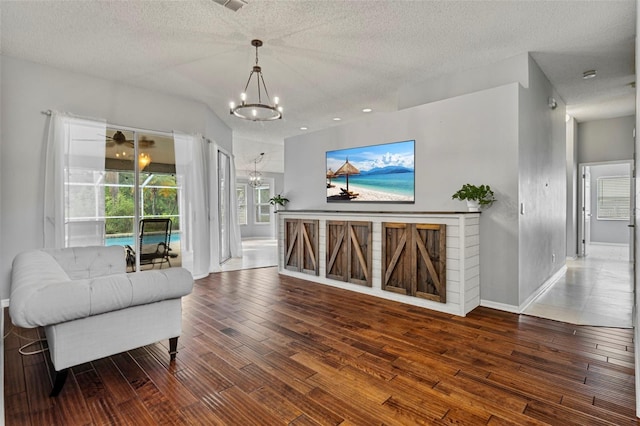 28707 Raleigh Pl, Wesley Chapel, FL 33545 - living room featuring a chandelier, hardwood / wood-style flooring, and a textured ceiling