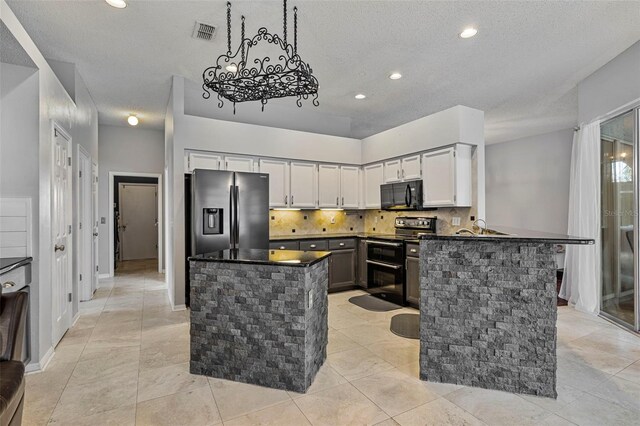 28707 Raleigh Pl, Wesley Chapel, FL 33545 - kitchen with double oven range, stainless steel refrigerator with ice dispenser, black microwave, dark countertops, and a textured ceiling