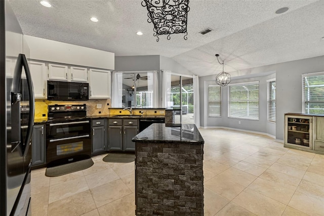 28707 Raleigh Pl, Wesley Chapel, FL 33545 - kitchen with black appliances, a textured ceiling, a chandelier, tasteful backsplash, and light tile patterned flooring