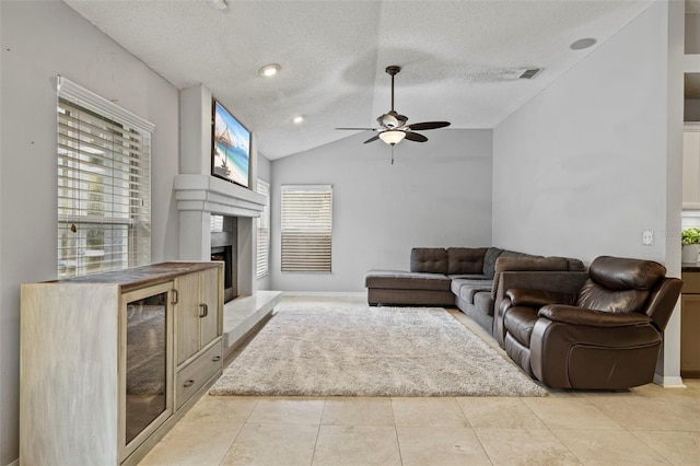 28707 Raleigh Pl, Wesley Chapel, FL 33545 - living area featuring a textured ceiling, lofted ceiling, a ceiling fan, a fireplace with raised hearth, and light tile patterned floors