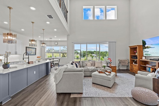 3179 Sailing Pier Ave, Winter Garden, FL 34787 - living room with a chandelier, a high ceiling, wood finished floors, and recessed lighting