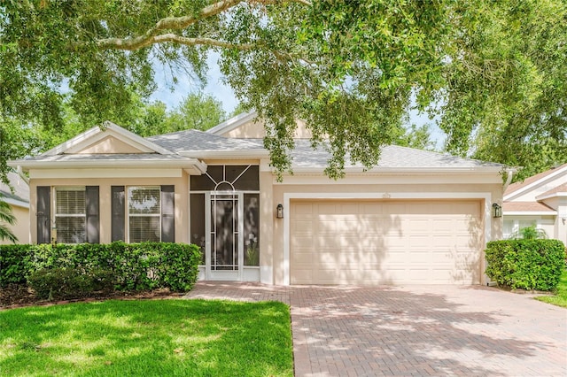 2173 Caledonian St, Clermont, FL 34711 - view of front of property featuring a garage, decorative driveway, stucco siding, and a front yard