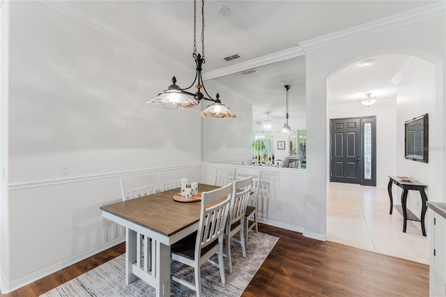 2173 Caledonian St, Clermont, FL 34711 - dining space with arched walkways, ornamental molding, and wood finished floors