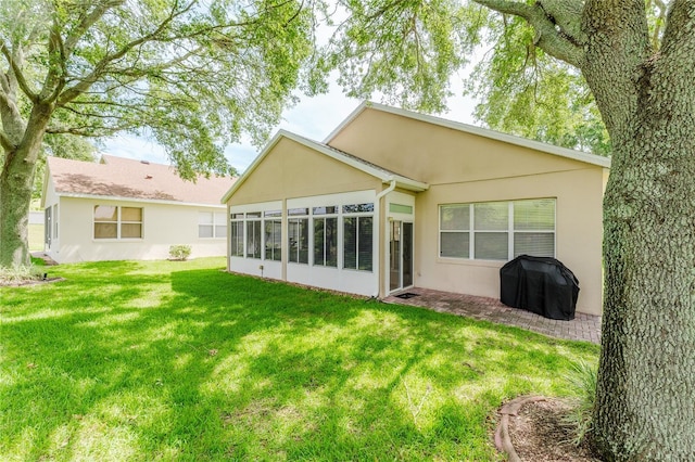 2173 Caledonian St, Clermont, FL 34711 - back of property with a sunroom, a lawn, and stucco siding