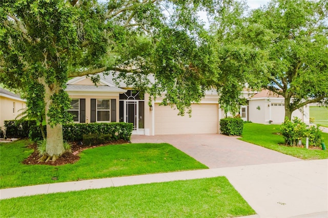 2173 Caledonian St, Clermont, FL 34711 - view of front of property featuring driveway, a front yard, stucco siding, a garage, and a shingled roof