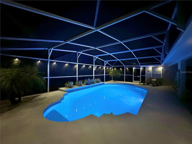 5205 Hammock Cir, Saint Cloud, FL 34771 - pool at night featuring a patio, an outdoor pool, and glass enclosure