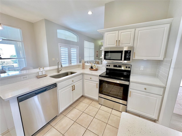 5205 Hammock Cir, Saint Cloud, FL 34771 - kitchen featuring stainless steel appliances, a peninsula, light tile patterned floors, recessed lighting, and white cabinets