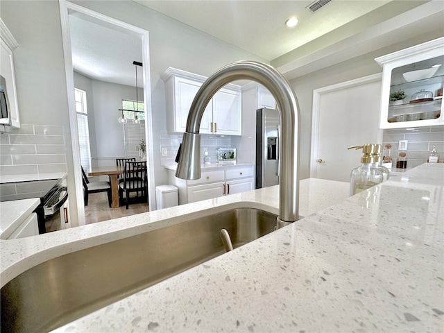 5205 Hammock Cir, Saint Cloud, FL 34771 - kitchen view of range with electric cooktop, decorative backsplash, light stone counters, and recessed lighting