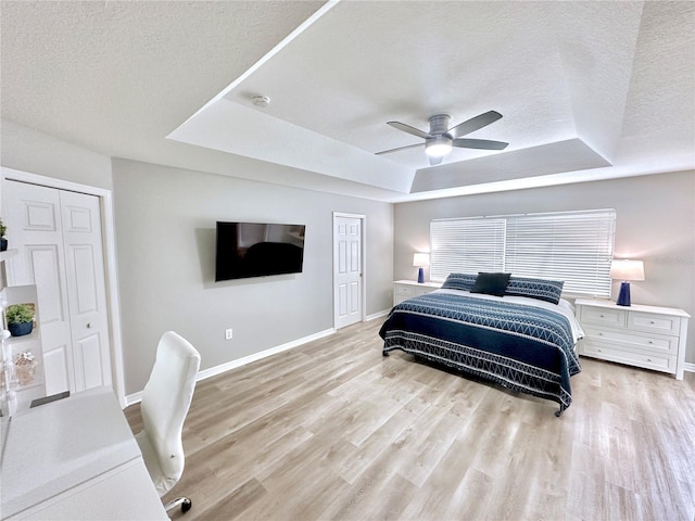 5205 Hammock Cir, Saint Cloud, FL 34771 - bedroom with a tray ceiling, a textured ceiling, light wood-style floors, a ceiling fan, and a closet