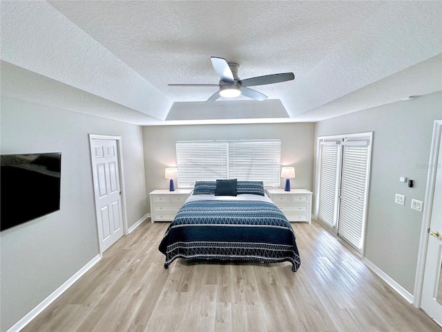 5205 Hammock Cir, Saint Cloud, FL 34771 - bedroom with a raised ceiling, a textured ceiling, light wood-style flooring, ceiling fan, and a closet