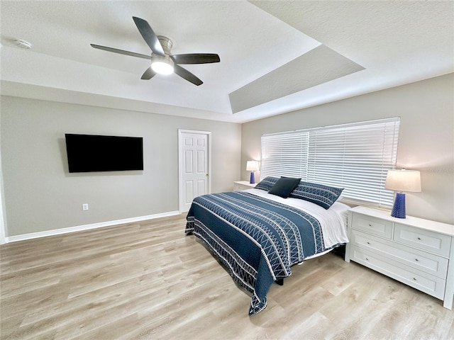 5205 Hammock Cir, Saint Cloud, FL 34771 - bedroom featuring a tray ceiling, light wood-type flooring, ceiling fan, and multiple windows
