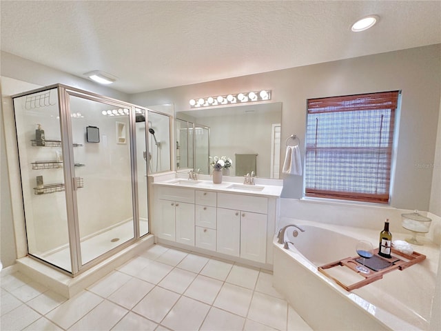 5205 Hammock Cir, Saint Cloud, FL 34771 - bathroom with a shower stall, double vanity, tile patterned floors, a garden tub, and a textured ceiling