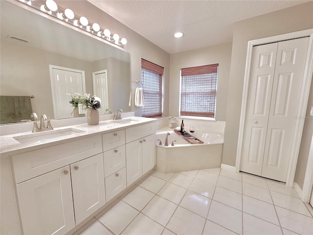 5205 Hammock Cir, Saint Cloud, FL 34771 - full bathroom featuring double vanity, a bath, tile patterned flooring, and a textured ceiling