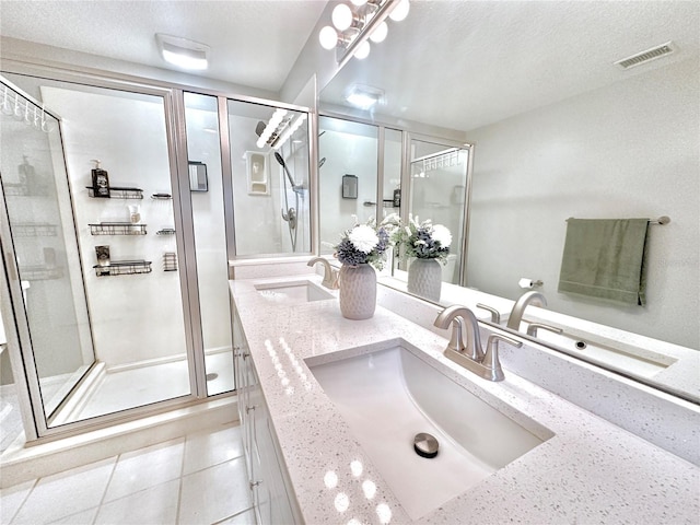 5205 Hammock Cir, Saint Cloud, FL 34771 - bathroom with double vanity, a stall shower, a textured ceiling, and tile patterned flooring