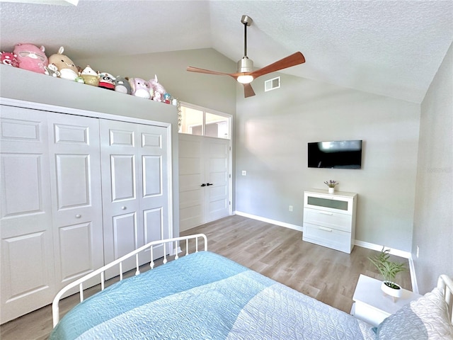5205 Hammock Cir, Saint Cloud, FL 34771 - bedroom with wood finished floors, vaulted ceiling, a textured ceiling, a closet, and ceiling fan