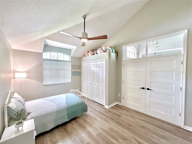 5205 Hammock Cir, Saint Cloud, FL 34771 - bedroom with light wood finished floors, lofted ceiling, a ceiling fan, and a textured ceiling