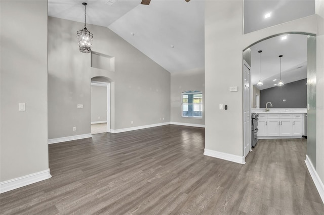 1031 Seneca Trl, Saint Cloud, FL 34772 - unfurnished living room featuring arched walkways, high vaulted ceiling, ceiling fan, and dark wood-style floors