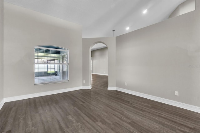 1031 Seneca Trl, Saint Cloud, FL 34772 - empty room featuring dark wood-type flooring, arched walkways, and vaulted ceiling