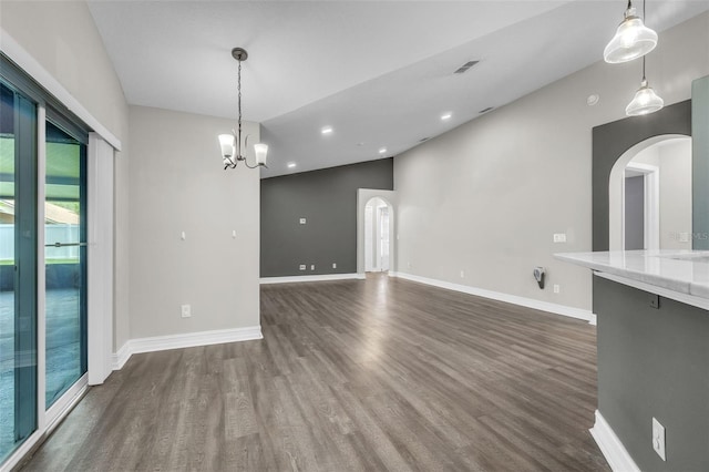 1031 Seneca Trl, Saint Cloud, FL 34772 - spare room featuring arched walkways, dark wood-style floors, a chandelier, recessed lighting, and lofted ceiling