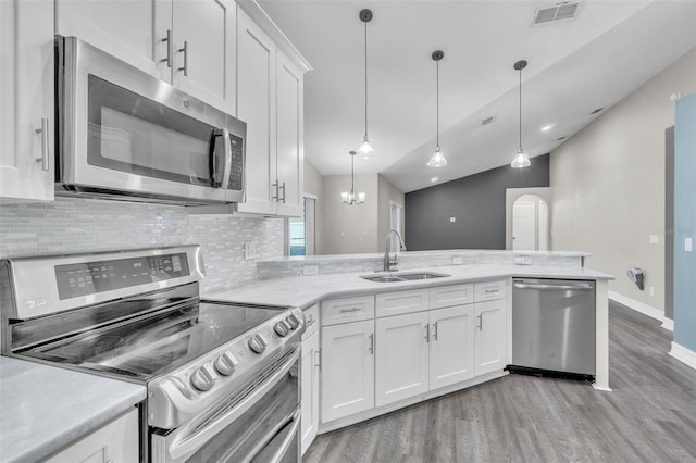 1031 Seneca Trl, Saint Cloud, FL 34772 - kitchen with appliances with stainless steel finishes, light wood-style flooring, backsplash, light countertops, and white cabinetry