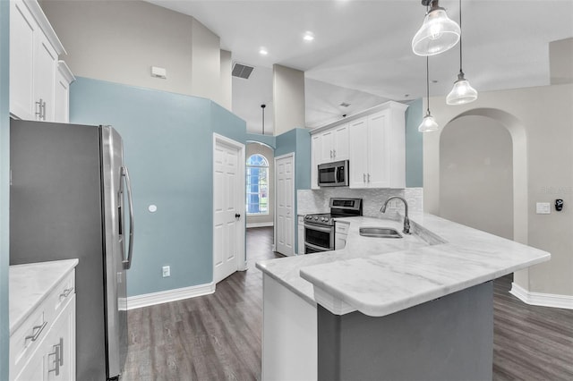 1031 Seneca Trl, Saint Cloud, FL 34772 - kitchen with appliances with stainless steel finishes, dark wood finished floors, arched walkways, white cabinetry, and recessed lighting