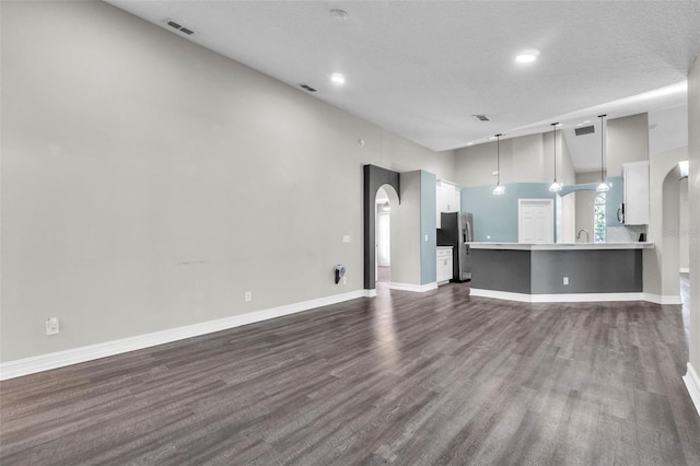 1031 Seneca Trl, Saint Cloud, FL 34772 - unfurnished living room with dark wood-type flooring, arched walkways, and recessed lighting
