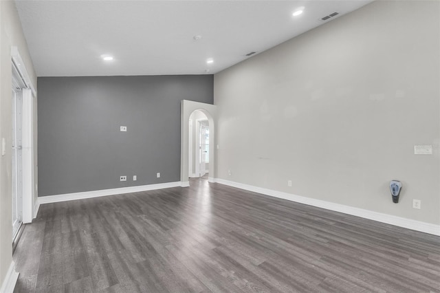 1031 Seneca Trl, Saint Cloud, FL 34772 - spare room with dark wood-type flooring, arched walkways, vaulted ceiling, and recessed lighting