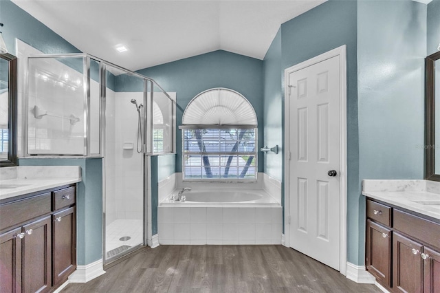 1031 Seneca Trl, Saint Cloud, FL 34772 - bathroom featuring a stall shower, a bath, two vanities, wood finished floors, and lofted ceiling