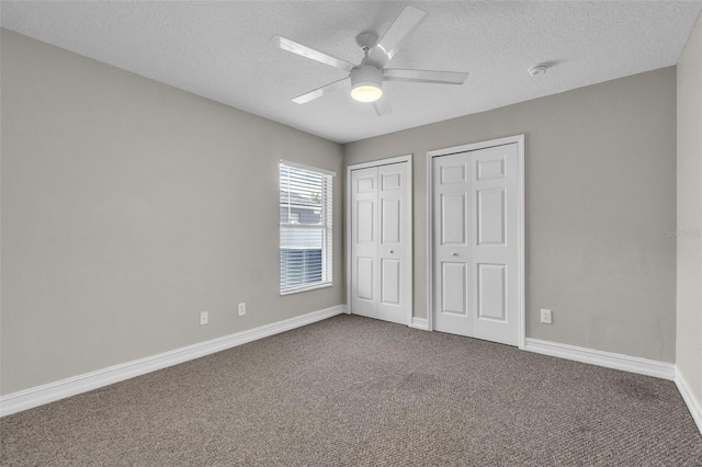 1031 Seneca Trl, Saint Cloud, FL 34772 - unfurnished bedroom featuring two closets, carpet, a textured ceiling, and a ceiling fan