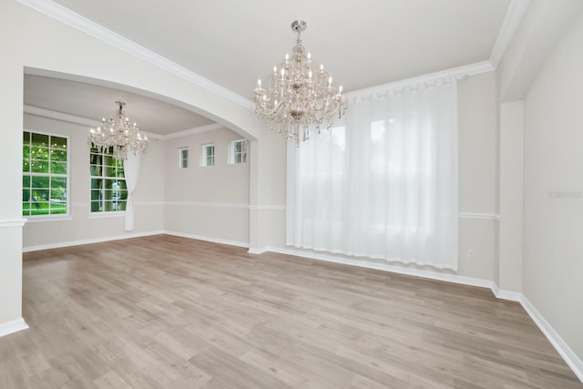 5552 Remsen Cay Ln, Windermere, FL 34786 - unfurnished dining area featuring a chandelier, light wood-type flooring, arched walkways, and crown molding