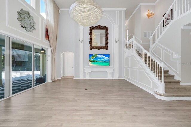 5552 Remsen Cay Ln, Windermere, FL 34786 - foyer with stairs, wood finished floors, a chandelier, a towering ceiling, and ornamental molding