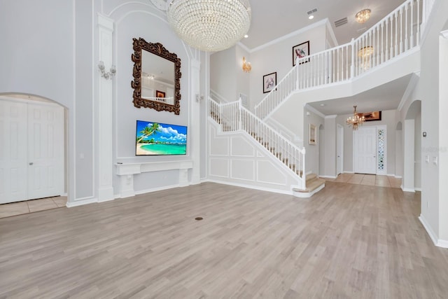 5552 Remsen Cay Ln, Windermere, FL 34786 - foyer entrance with a chandelier, arched walkways, a high ceiling, wood finished floors, and stairway