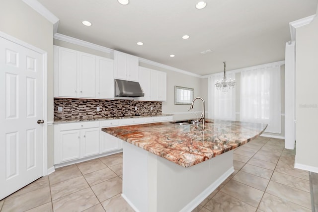 5552 Remsen Cay Ln, Windermere, FL 34786 - kitchen with under cabinet range hood, ornamental molding, light tile patterned floors, light stone counters, and white cabinets