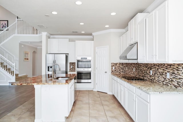 5552 Remsen Cay Ln, Windermere, FL 34786 - kitchen featuring under cabinet range hood, appliances with stainless steel finishes, light stone counters, an island with sink, and tasteful backsplash