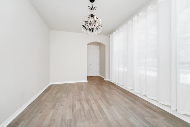 5552 Remsen Cay Ln, Windermere, FL 34786 - spare room with arched walkways, wood finished floors, and a chandelier