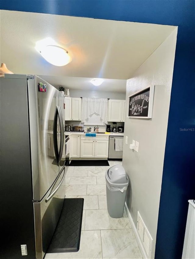 1034 Villa Ln Unit 18, Apopka, FL 32712 - kitchen featuring stainless steel appliances, white cabinetry, light marble finish floors, and light countertops