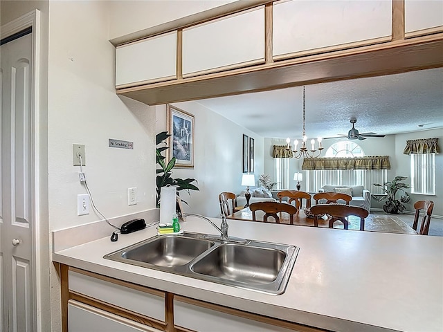 8722 Rockingham Ter Unit B, Kissimmee, FL 34747 - kitchen with open floor plan, light countertops, white cabinets, a chandelier, and pendant lighting