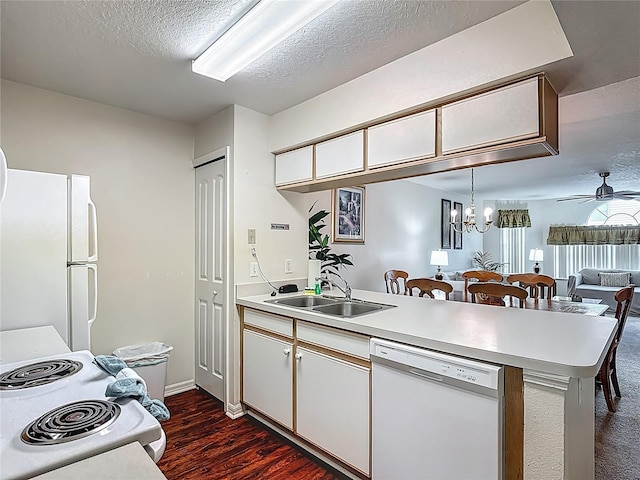8722 Rockingham Ter Unit B, Kissimmee, FL 34747 - kitchen with white appliances, a peninsula, light countertops, dark wood finished floors, and a textured ceiling