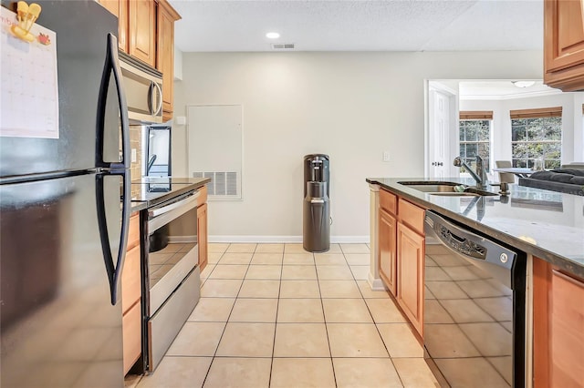 698 Roaring Dr Unit 382, Altamonte Springs, FL 32714 - kitchen featuring stainless steel appliances, dark stone counters, brown cabinets, light tile patterned floors, and recessed lighting
