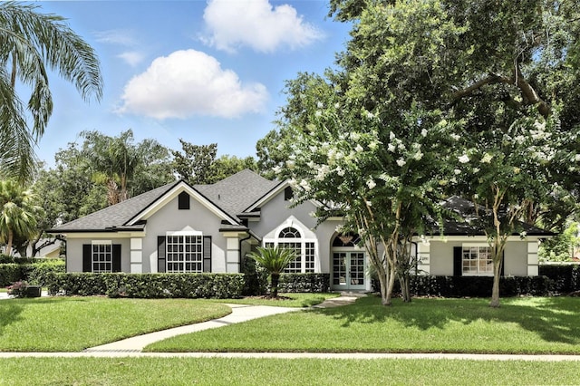 2890 Wild Ginger Ct, Winter Park, FL 32792 - view of front of property featuring french doors, stucco siding, a front lawn, and roof with shingles