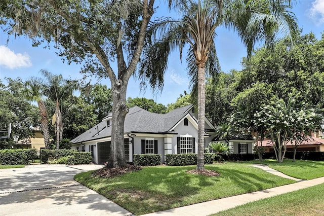 2890 Wild Ginger Ct, Winter Park, FL 32792 - view of front of home with stucco siding, a garage, a front lawn, concrete driveway, and a shingled roof