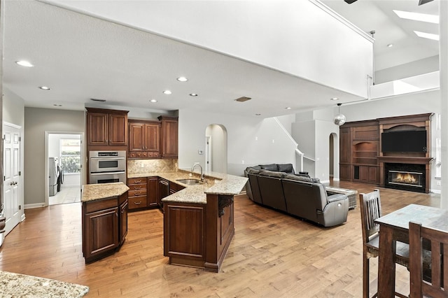 2890 Wild Ginger Ct, Winter Park, FL 32792 - kitchen with arched walkways, stainless steel double oven, a peninsula, open floor plan, and recessed lighting
