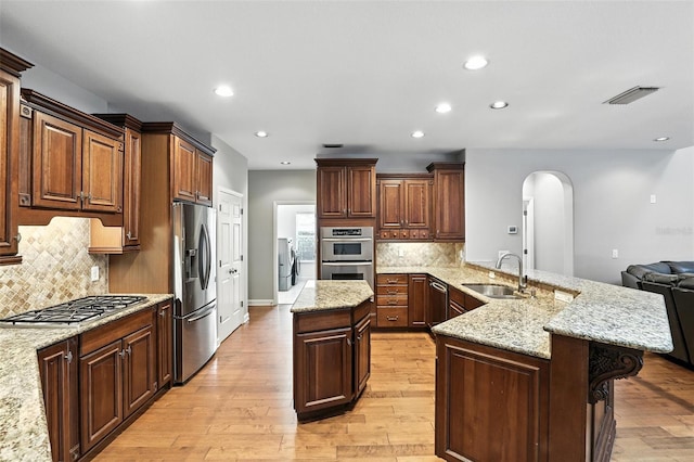 2890 Wild Ginger Ct, Winter Park, FL 32792 - kitchen with stainless steel appliances, arched walkways, recessed lighting, light wood-type flooring, and a peninsula