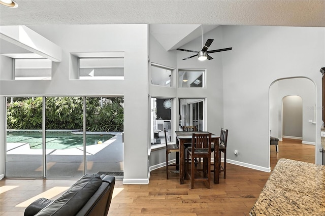 2890 Wild Ginger Ct, Winter Park, FL 32792 - dining room with ceiling fan, arched walkways, a high ceiling, wood finished floors, and a textured ceiling